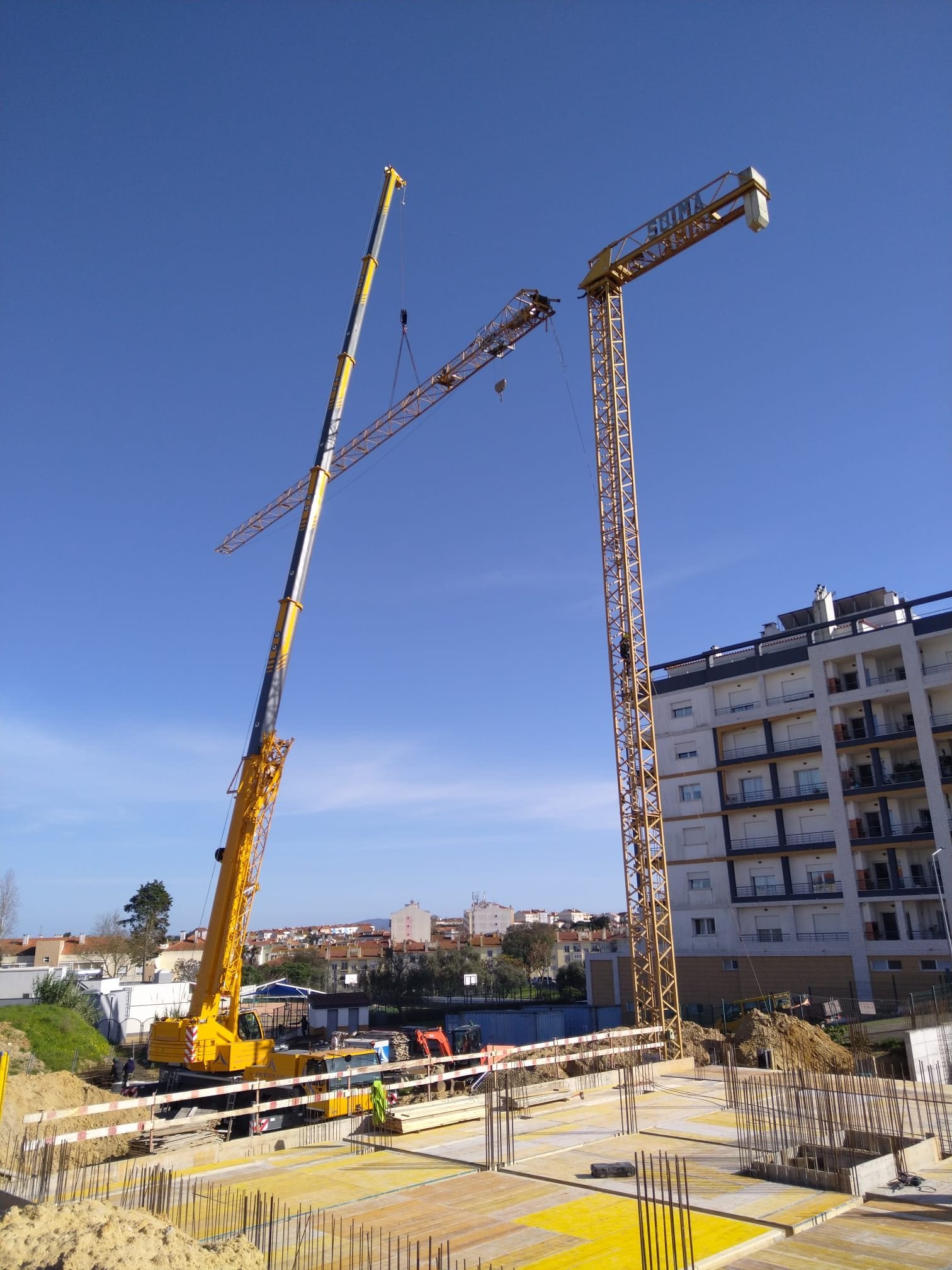 Cranes over the site, with reinforcement and formwork in the foreground