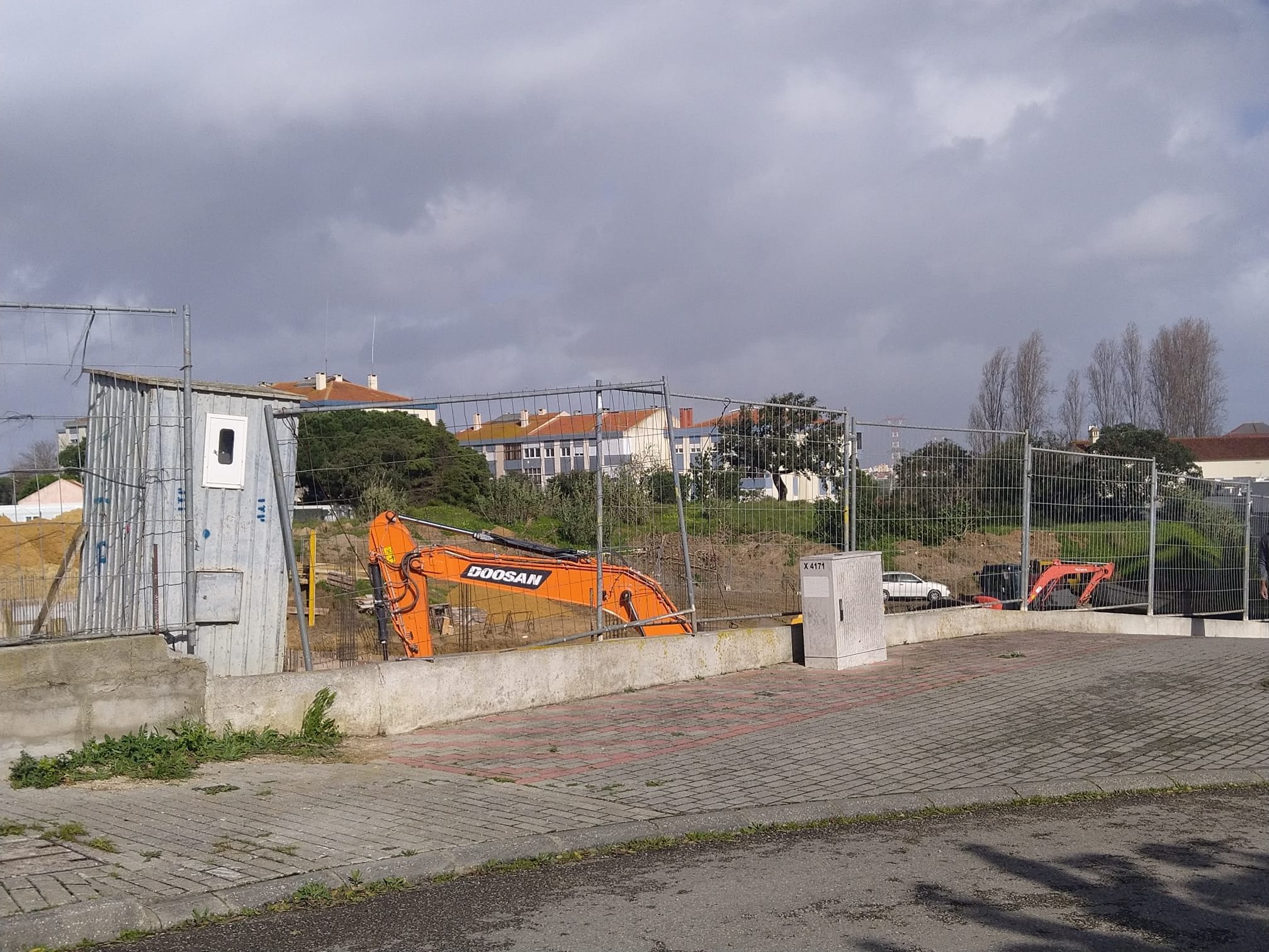 Site entrance with a site cabin and an excavator